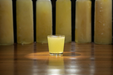  lemon alcoholic cocktail in a shot glass on a totally wooden background