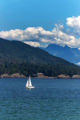 Sail boat drifting towards the island on the Pacific Ocean, BC, Canada