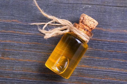 Bottle with oil on a wooden table.