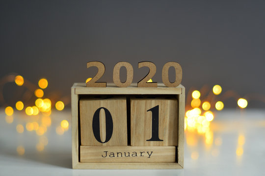 Wooden Calendar 1 JANUARY with Christmas and New Year Decorate on grey background,wooden numbers 2020 with bokeh New Year's lights.The concept of the New Year, New Year's Eve, winter holidays.