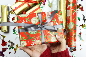 Women's hands decorate the gift box. Christmas composition on white background.