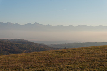 Golden fields in Carpathian Mountains. Mountains and barley cut fields in the horizon, golden hour photo-shoot. Golden fall panorama