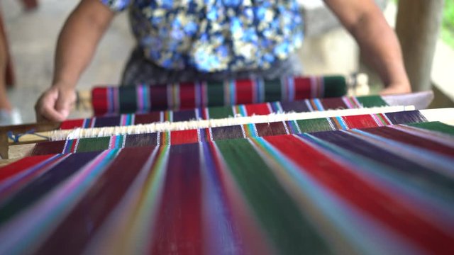 Women is working on antigue wooden machine to tailor and sew clothes. Fast fashion clothing production.