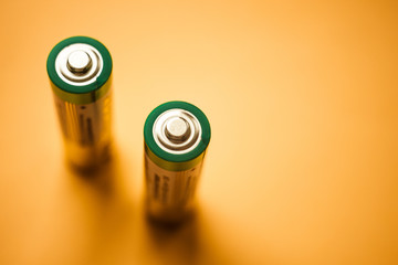 Two new batteries on the orange table, top view.
