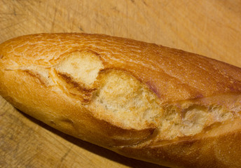fresh crispy baguette lies on a wooden board