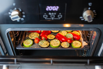 Baked grilled vegetables. Baked peppers, tomatoes, zucchini, eggplant, rosemary and herbs. Cooking dinner in the oven. Vegetarian food in the oven. Vegan cooking. Proper and healthy nutrition