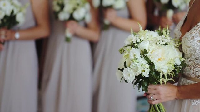 Close up side view of bridesmaids holding wedding elegant bouquet with white roses and eustoma (lisianthus)