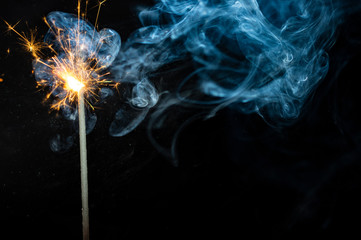 sparkler on black background with smoke