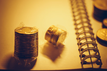 Collection of golden metal money on the notebook paper.