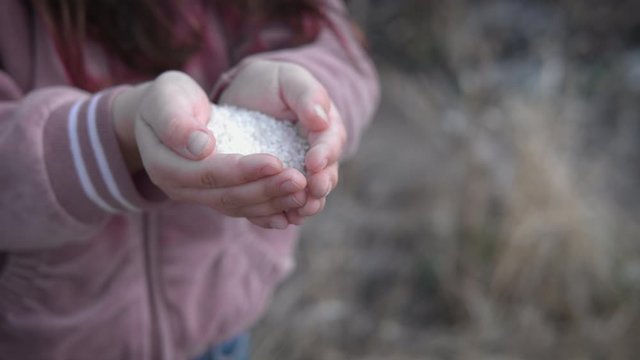 Starvation. Homeless child's hands with a handful of rice.