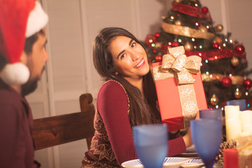 Chica con regalo y árbol de navidad esperando las fiestas