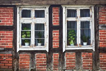 Wooden windows and half-timbered wall of a rural cottage in Poland.