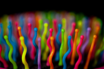 Abstract background of colorful waves in motion on black. Bokeh of defocused curves, blurred neon blue, yellow and red leds, imitation of glowing sperm flow, wallpapers and banners
