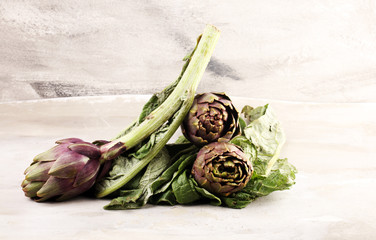 artichokes on grey background. fresh raw organic artichoke flower.