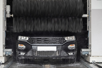 a black car stands in a car wash and is washed