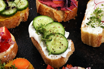 Assorted bruschetta with various toppings. Appetizing bruschetta or brie crostini. Variety of small sandwiches. Mix bruschetta on table