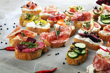 Assorted bruschetta with various toppings. Appetizing bruschetta or brie crostini. Variety of small...