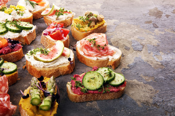 Assorted bruschetta with various toppings. Appetizing bruschetta or brie crostini. Variety of small sandwiches. Mix bruschetta on table