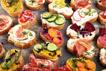 Assorted bruschetta with various toppings. Appetizing bruschetta or brie crostini. Variety of small sandwiches. Mix bruschetta on table