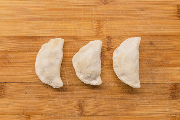 Homemade frozen dumplings on the wooden bamboo desk