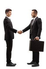 Young man in a suit shaking hands with a businessman