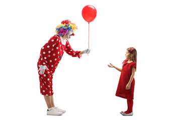 Clown giving a red balloon to a little girl