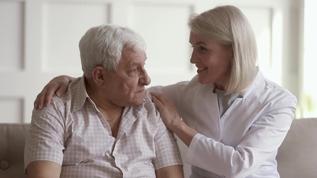 Mature woman nurse talking to old man help with problem