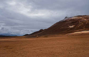 Hverir geothermal area in North Iceland. dy geysers and sulfur field. Orange mountains Iceland.