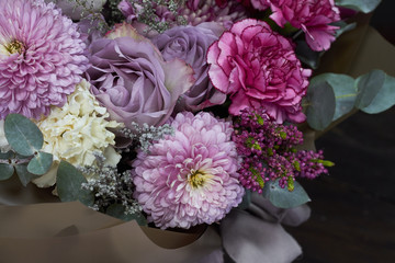 Pink and purple toned bouquet in vintage style on a dark background, selective focus