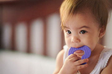 Child sucking purple toy