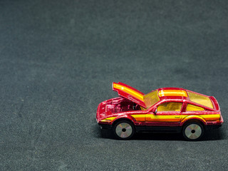 Car with an open engine cover - small car model (toy)