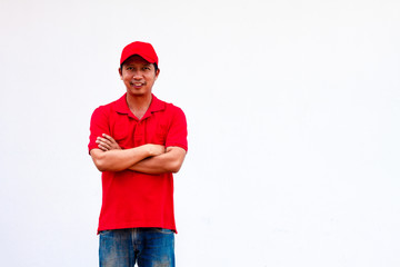 Men wearing red shirts and hats stand happily with their arms crossed.
