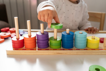 girl playing with colored pieces the pieces are made of wood and ecological painting