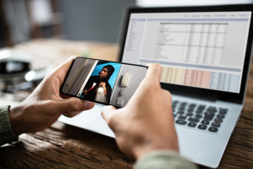 Businessperson Watching Video On Mobilephone