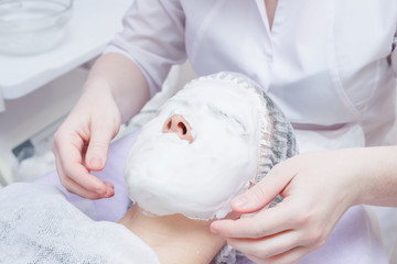 A cosmetologist does an ultrasonic cleaning of the skin of the face.