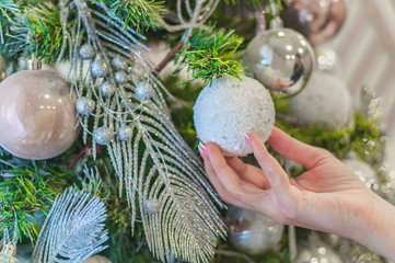 female hand decorates a Christmas tree