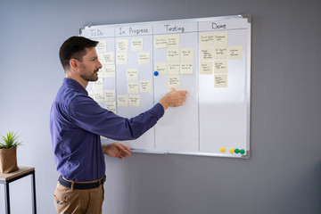 Fototapeta premium Businessman Writing On Sticky Notes