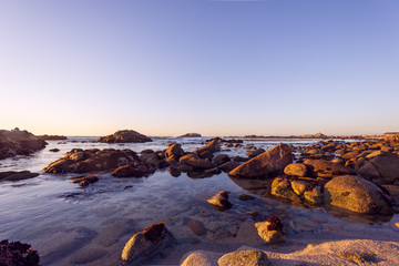 sunset on rocky coast of the sea