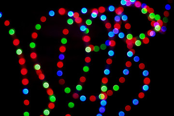 Bokeh effect on round red, green and blue lights. Abstract blurred leds garland for background.