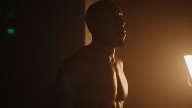African-American athlete running on treadmill, muscular built, listening to music while training in gym, dramatic lightning, shot on Red Weapon Helium