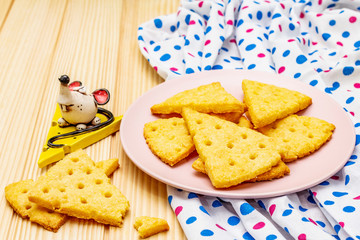 Funny kids cookies. Festive cheese crackers, New Year snack concept. Food, mouse sculpture, napkin. Wooden planks background