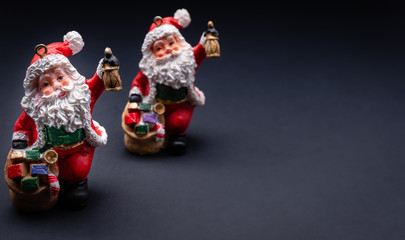 Christmas Santa Claus miniature toy decoration isolated on black gradient background with copy space.