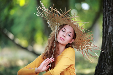 Jeune femme assise portant un chapeau de paille