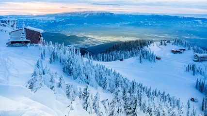 Poiana Brasov, Romania - cable car ski resort, skiers and snowboarders enjoy the ski slopes in winter resort with trees covered in snow.