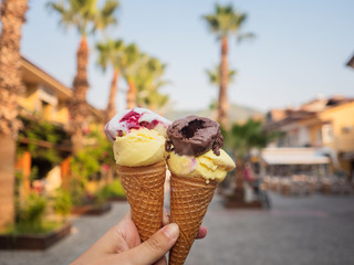 Two servings of ice cream in a waffle cone. The girl holds in her hand ice cream for two, ice cream...