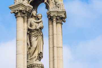 Fototapeta premium Statue of Mother Mary holding baby Jesus outside the Notre Dame Cathedral in Paris, France.