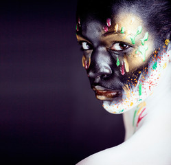 woman with creative makeup closeup like drops of colors, facepaint close up halloween