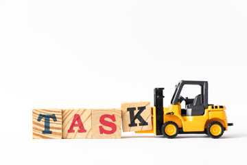Toy forklift hold wood letter block k to complete word task on white background