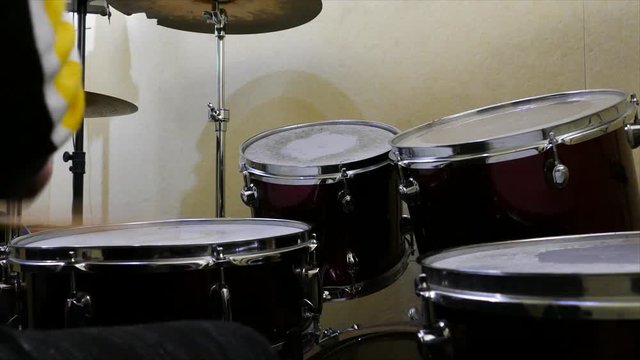 Young child plays drums on drumset