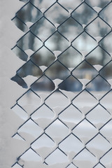 Chain link fence with snow on sunny winter day